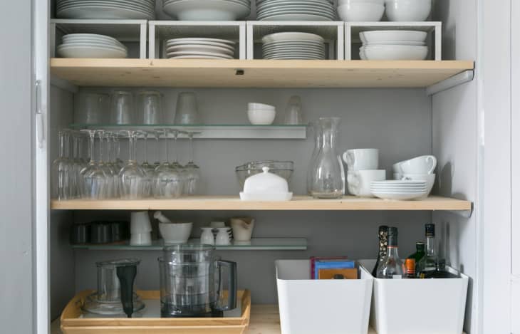 Shelf risers are used on the topmost shelf to store plates and bowls on top of each other; the shelves below store wine glasses, mugs, mortar & pestle, bowls, and some condiments